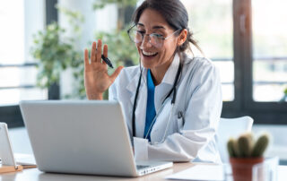 Ways healthcare professionals can improve telehealth appointments for patients, female doctor waving and smiling during telehealth appointment